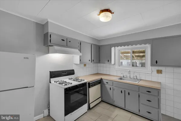 a kitchen with granite countertop a stove sink and cabinets