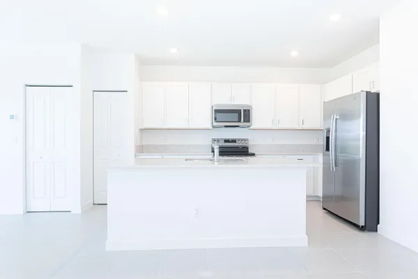 a kitchen with stainless steel appliances granite countertop a sink a stove and a refrigerator