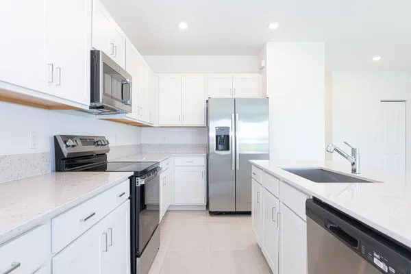 a kitchen with stainless steel appliances granite countertop white cabinets a stove top oven with wooden floor
