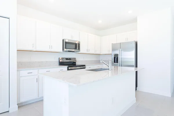 a kitchen with stainless steel appliances a refrigerator sink and microwave