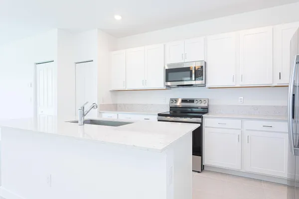 a kitchen with granite countertop white cabinets and white appliances