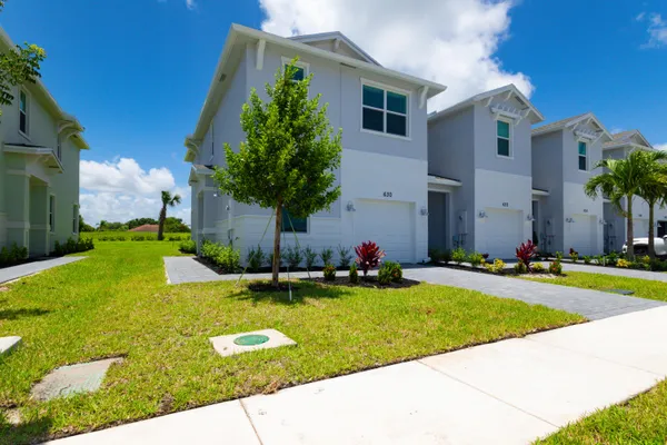 a front view of house with yard and trees
