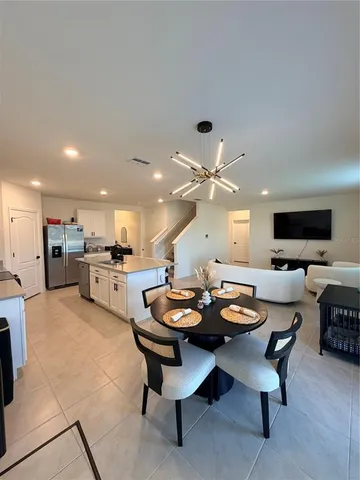 a dining room with furniture and kitchen view