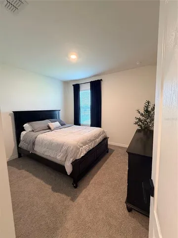 a bedroom with a bed and a potted plant