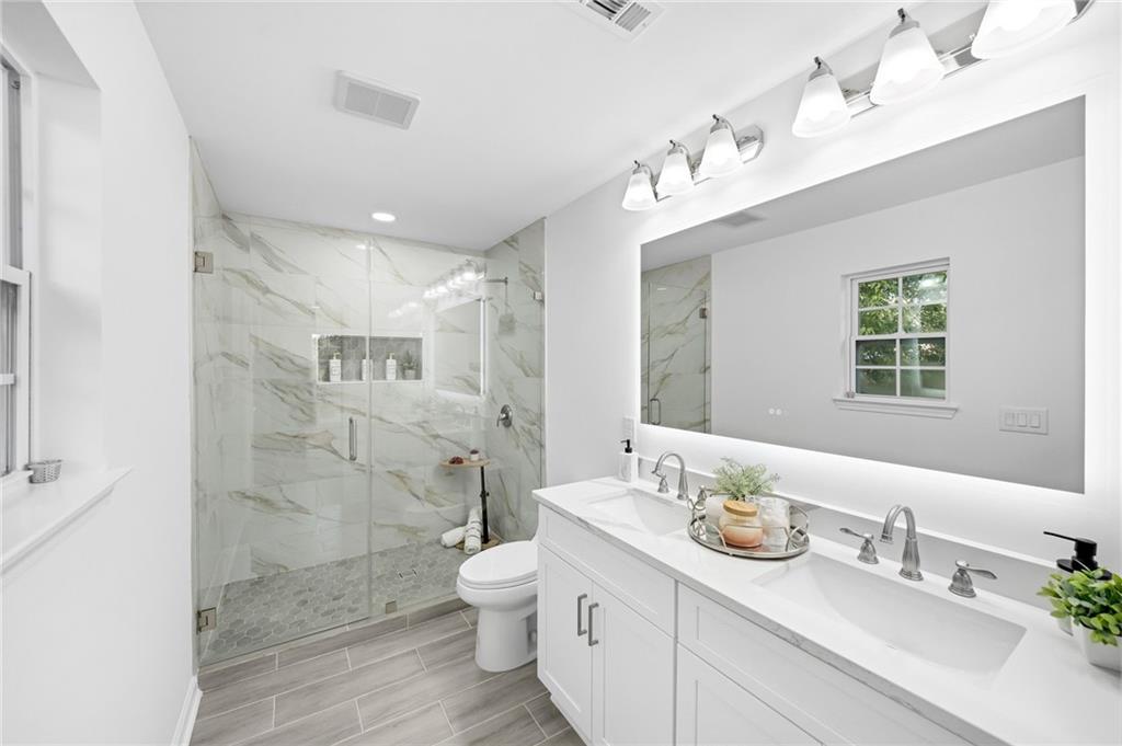 3892 Northstrand Drive Decatur, GA 30035 - Photo 14 of 25 a bathroom with a sink double vanity granite toilet and a shower