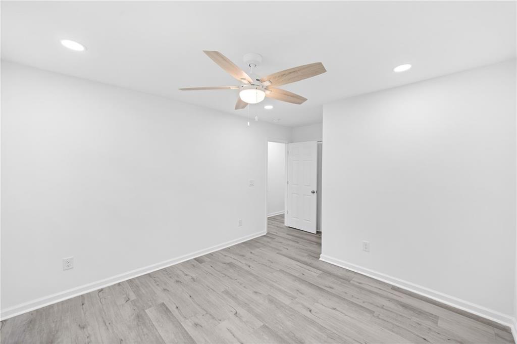 3892 Northstrand Drive Decatur, GA 30035 - Photo 20 of 25 an empty room with wooden floor and a ceiling fan