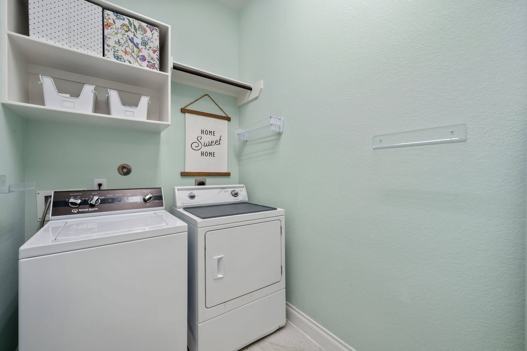 2119 Blackhawk Ridge Lane Manvel, TX 77578 - Photo 33 of 49 Utility / Laundry Room with built-in shelving, hanging rod, wall-mounted storage hooks, and ample space for a full-size washer and dryer — functional, organized, and move-in ready.