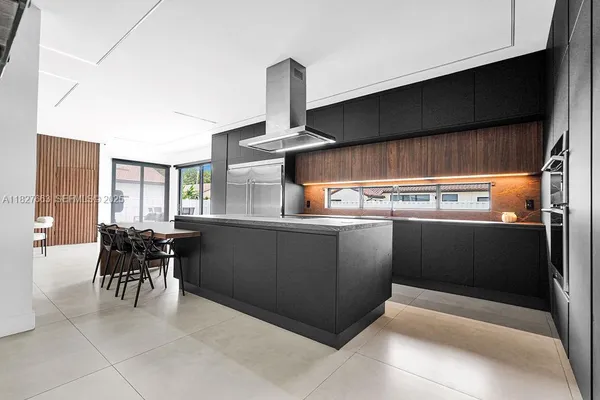 a large kitchen with kitchen island a large counter space a sink and appliances