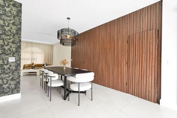 a living room with couches and kitchen view with wooden floor