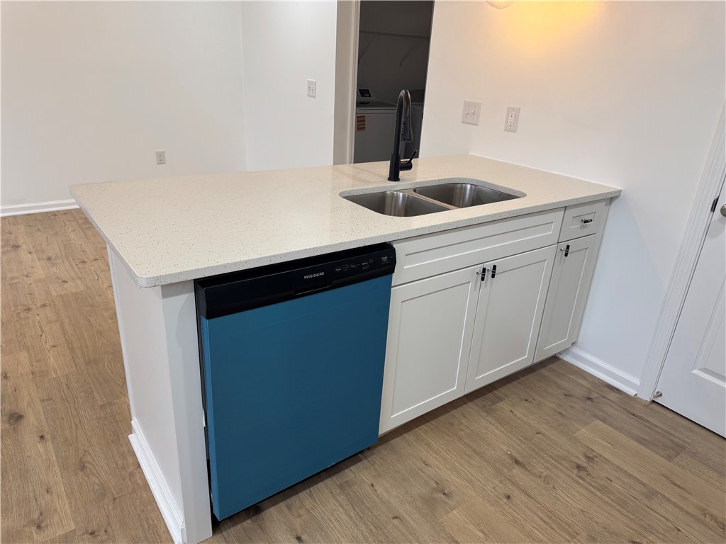701 Delia Street, Unit B Anderson, SC 29624 - Photo 11 of 25 This sleek kitchen island features a double sink, modern cabinetry, and durable flooring.