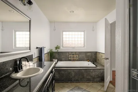 a bathroom with a tub a sink and a window