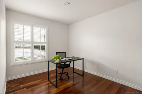 a view of a workspace with furniture and a window