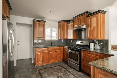 a kitchen with stainless steel appliances granite countertop a sink stove and refrigerator