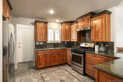 a kitchen with stainless steel appliances granite countertop a stove sink and cabinets