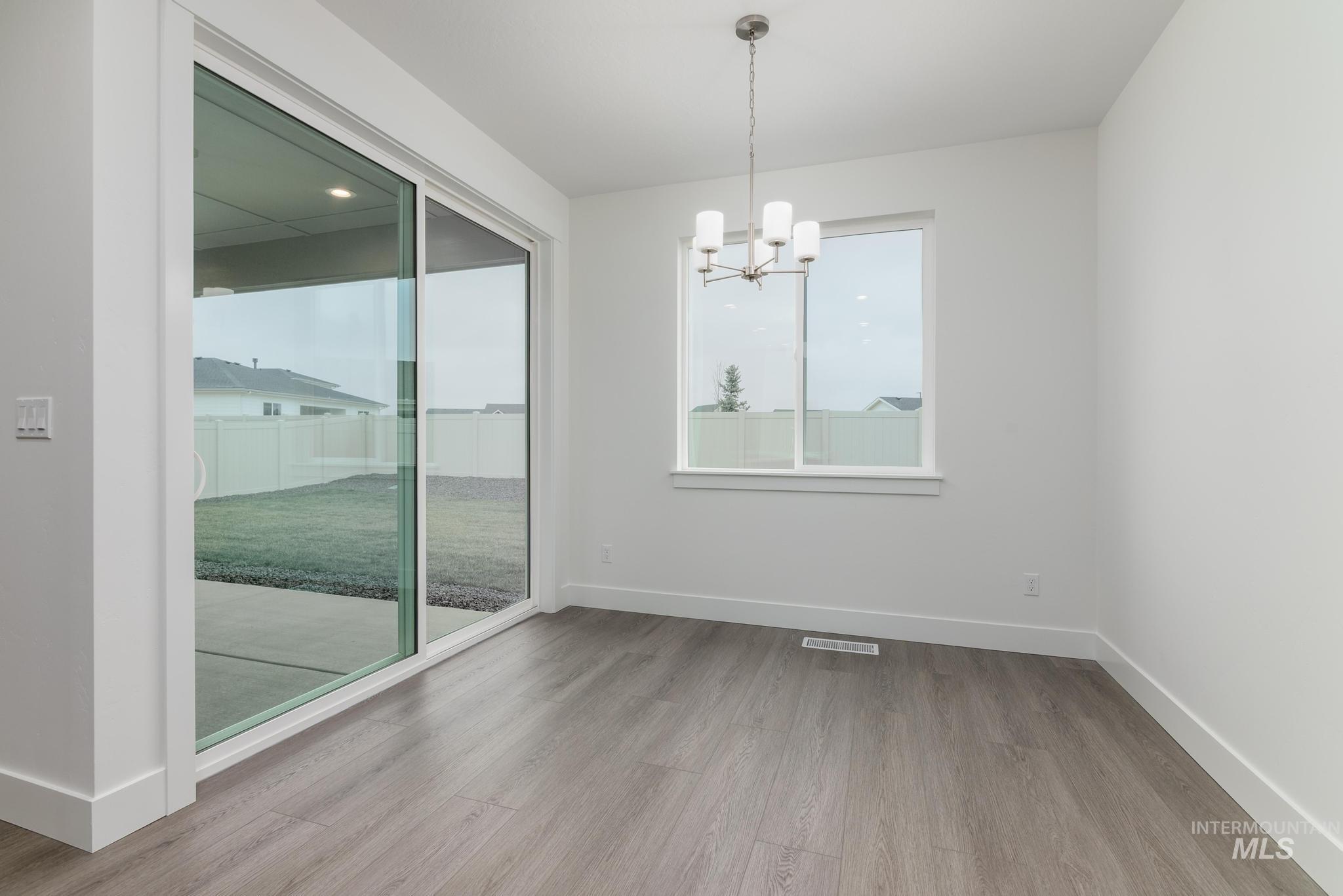 5923 West Snow Currant Street Meridian, ID 83646 - Photo 16 of 28 Spare room featuring a chandelier and light wood-style floors