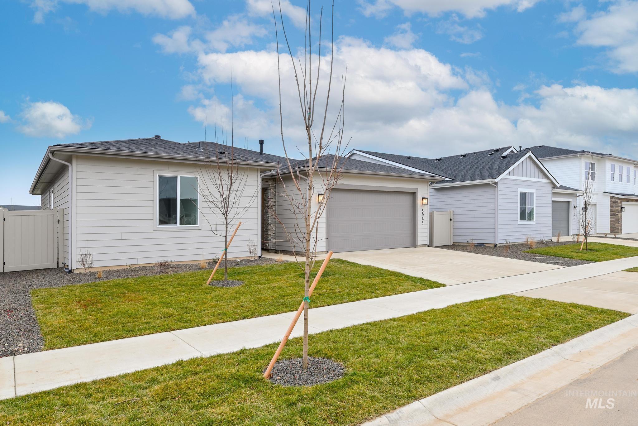 5923 West Snow Currant Street Meridian, ID 83646 - Photo 2 of 28 View of front facade with a gate, a garage, driveway, and roof with shingles