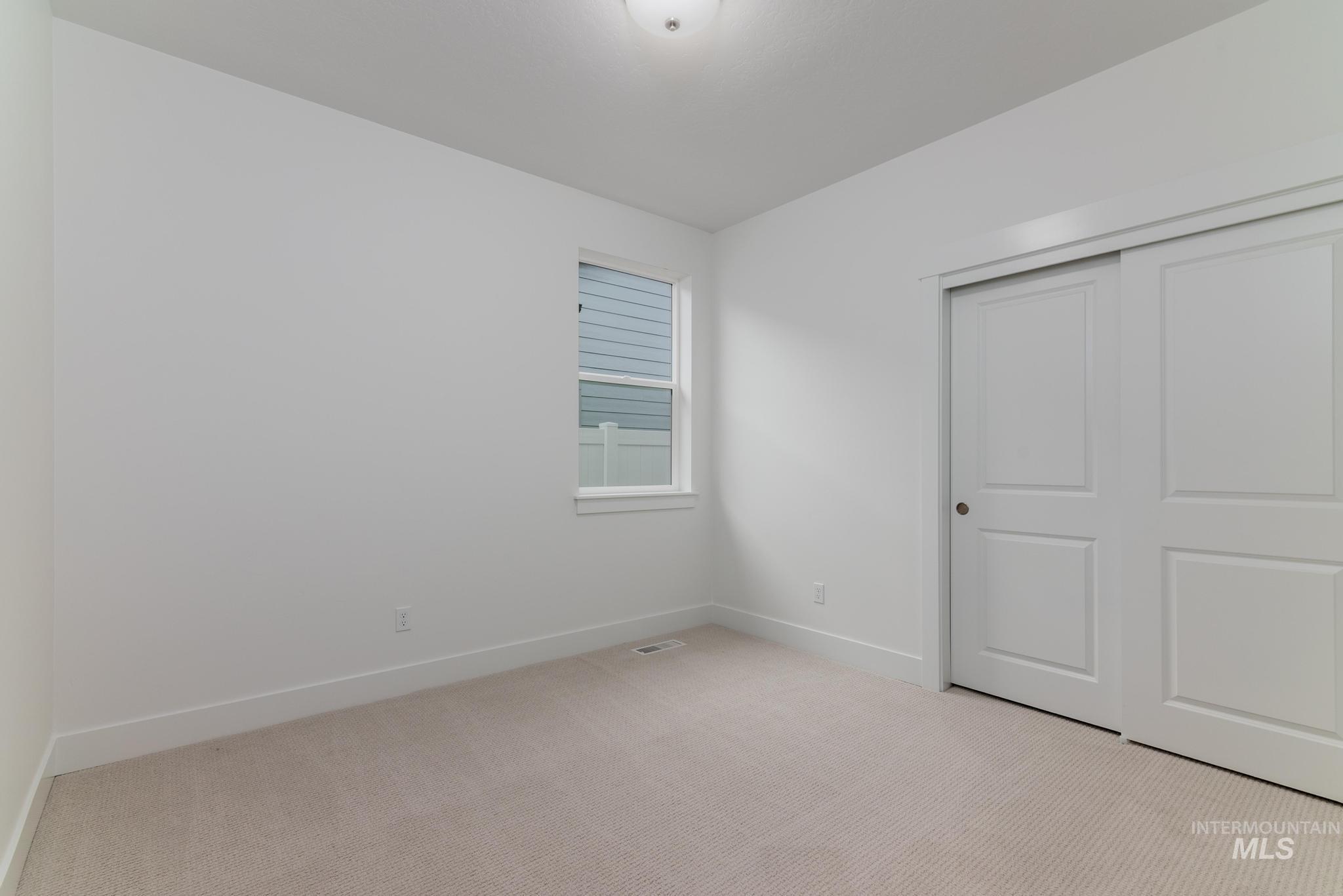 5923 West Snow Currant Street Meridian, ID 83646 - Photo 20 of 28 Unfurnished bedroom featuring light carpet and a closet