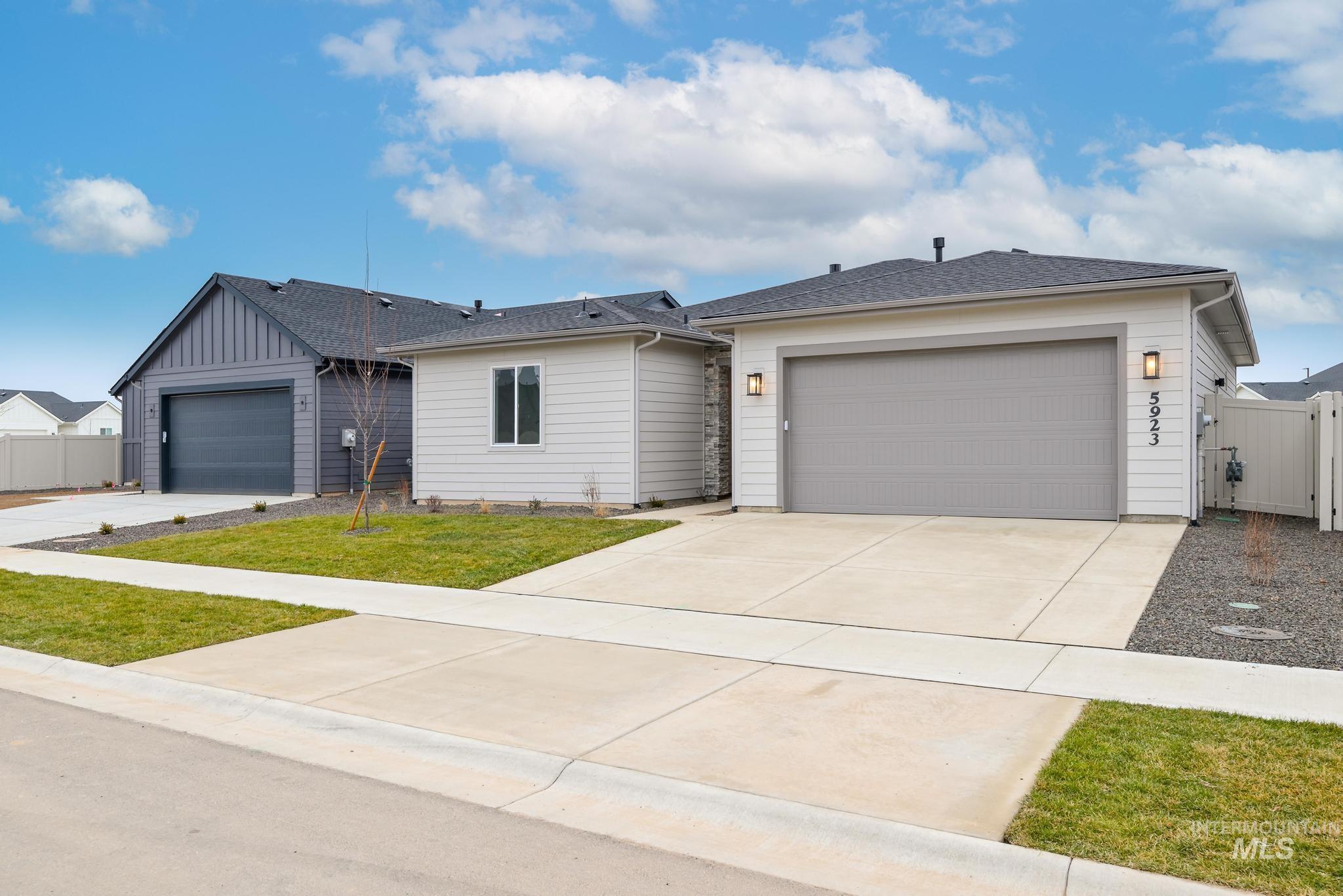 5923 West Snow Currant Street Meridian, ID 83646 - Photo 3 of 28 Single story home featuring a gate, concrete driveway, an attached garage, and a shingled roof