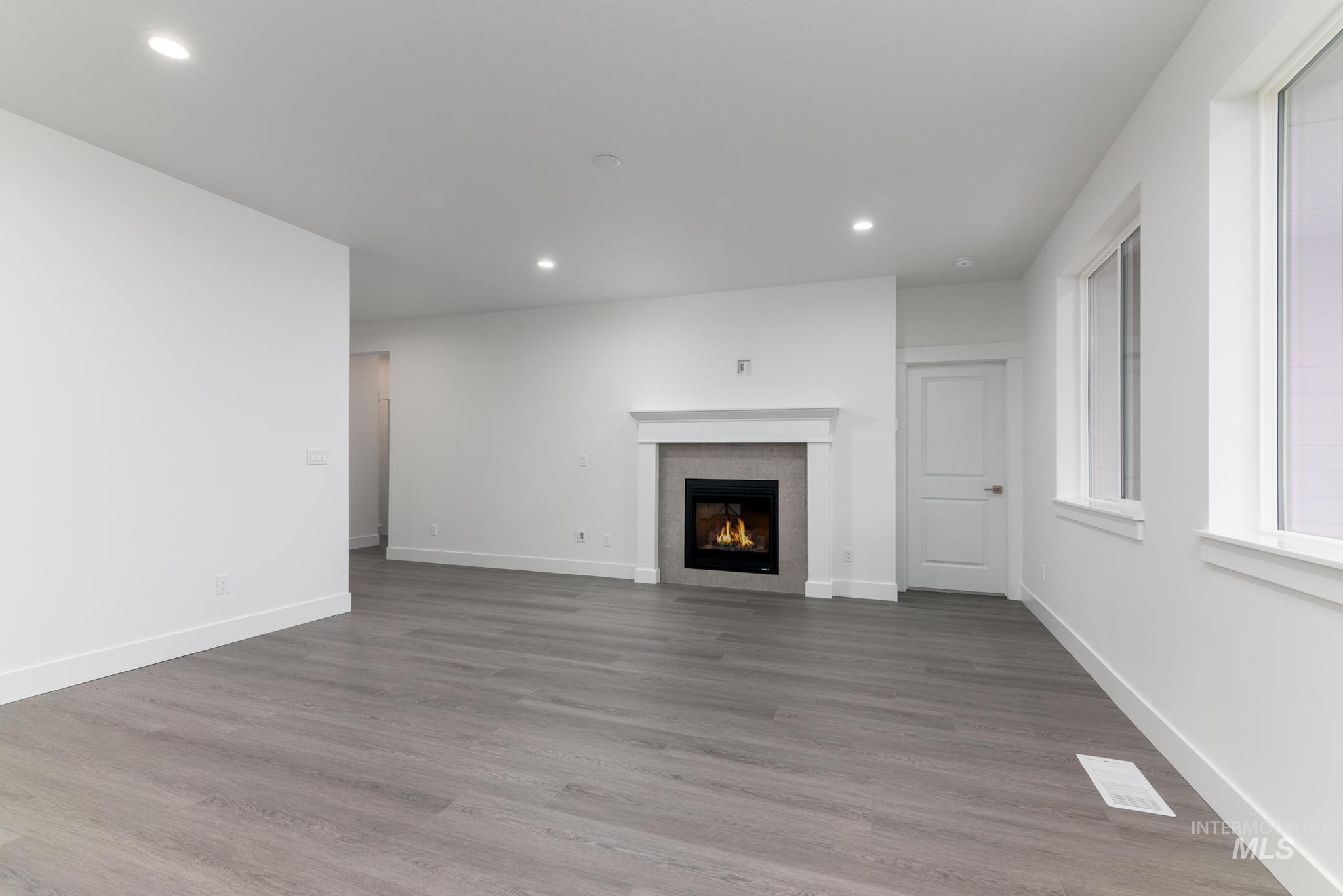 5923 West Snow Currant Street Meridian, ID 83646 - Photo 4 of 28 Unfurnished living room with recessed lighting, a fireplace, and light wood-style flooring