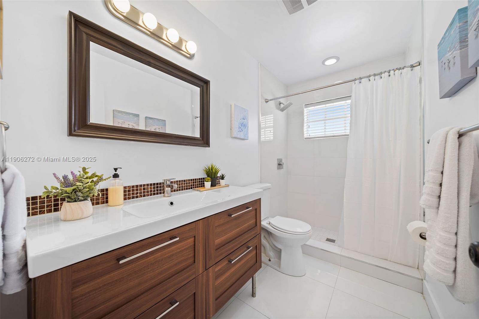 2761 Southwest 92nd Place Miami, FL 33165 - Photo 13 of 19 a bathroom with a toilet sink and mirror