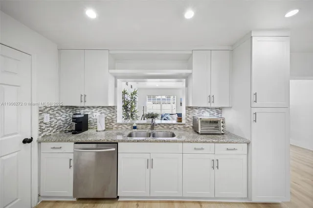 a kitchen with white cabinets and white appliances