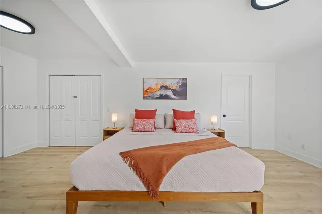 a bedroom with a bed and a painting on the wall