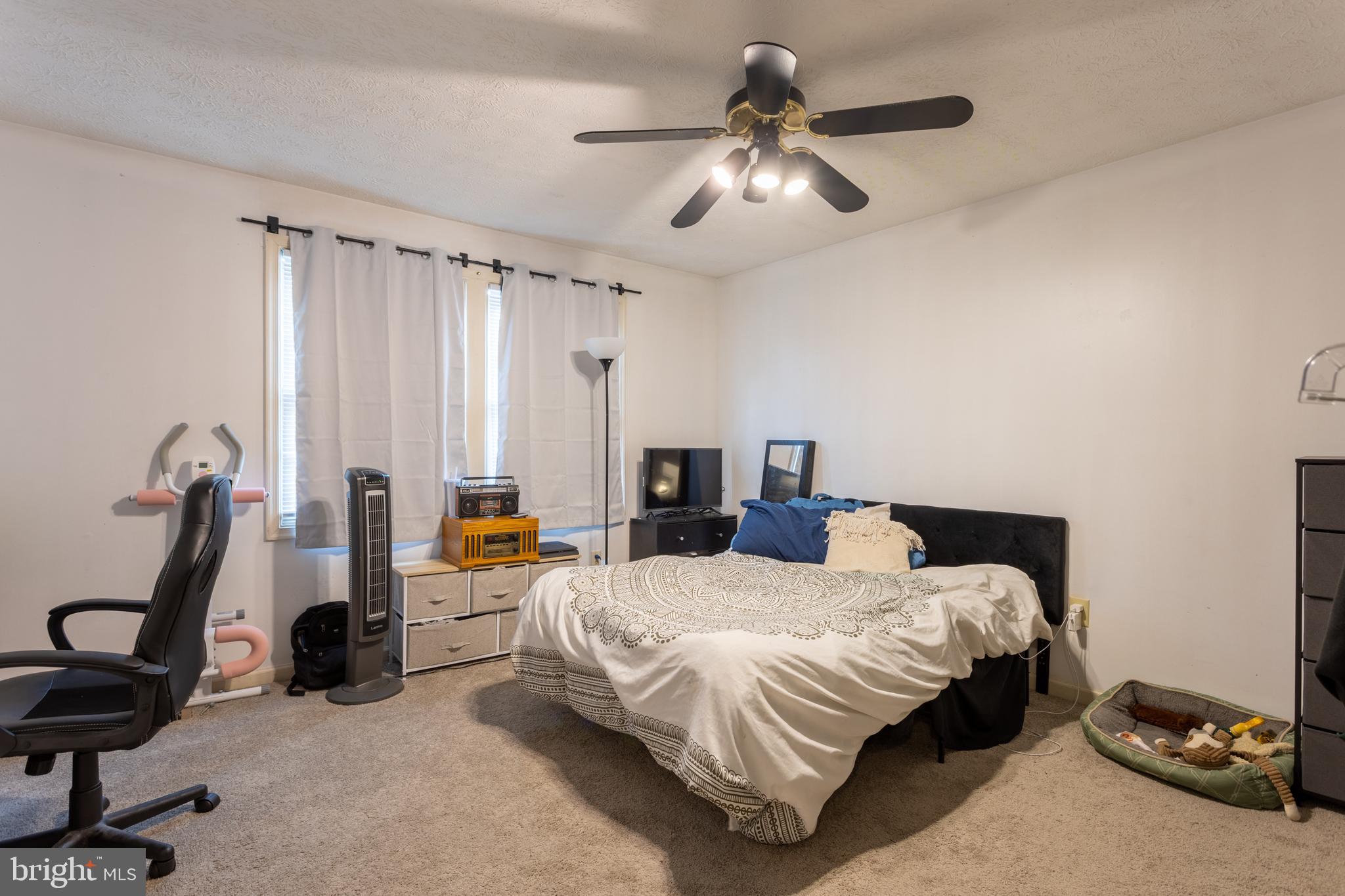 9525 Queens Guard Court Laurel, MD 20723 - Photo 22 of 36 a bedroom with bed and a chandelier