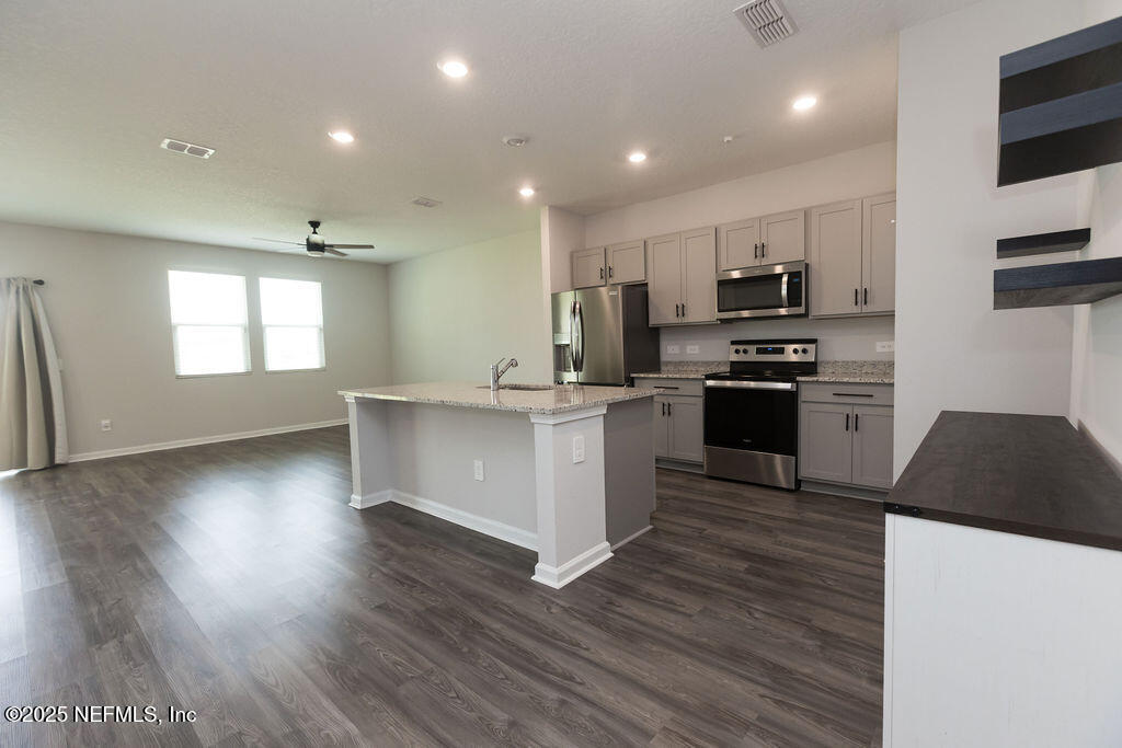 14655 Macadamia Lane Jacksonville, FL 32218 - Photo 14 of 24 a kitchen with stainless steel appliances a stove a sink a refrigerator and a microwave