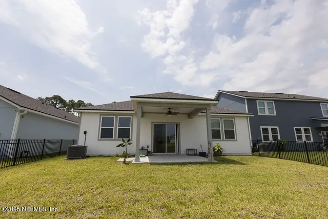 a view of a house with backyard and sitting area
