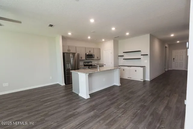 a view of kitchen with wooden floor and electronic appliances