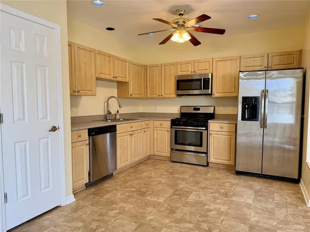 a kitchen with stainless steel appliances a stove a sink and a refrigerator