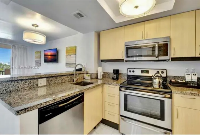 a kitchen with stainless steel appliances granite countertop a stove microwave and refrigerator