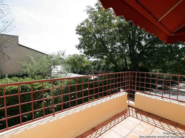 a view of a balcony with a floor to ceiling window and wooden fence