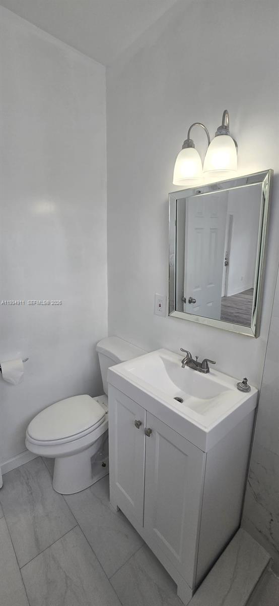 8430 Harding Avenue, Unit 4A Miami Beach, FL 33141 - Photo 13 of 43 a bathroom with a toilet sink and mirror