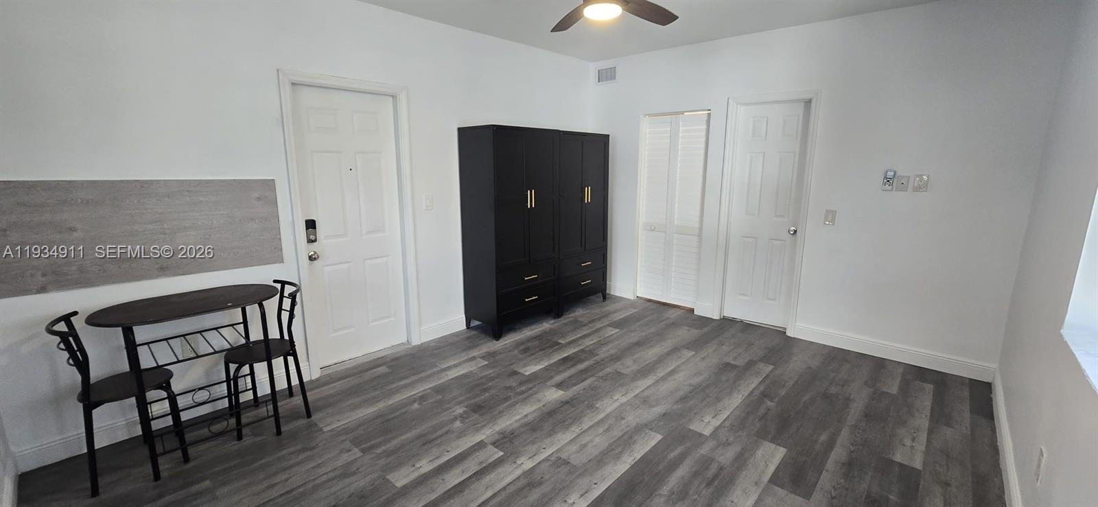 8430 Harding Avenue, Unit 4A Miami Beach, FL 33141 - Photo 3 of 43 a view of a livingroom with wooden floor and a chandelier fan