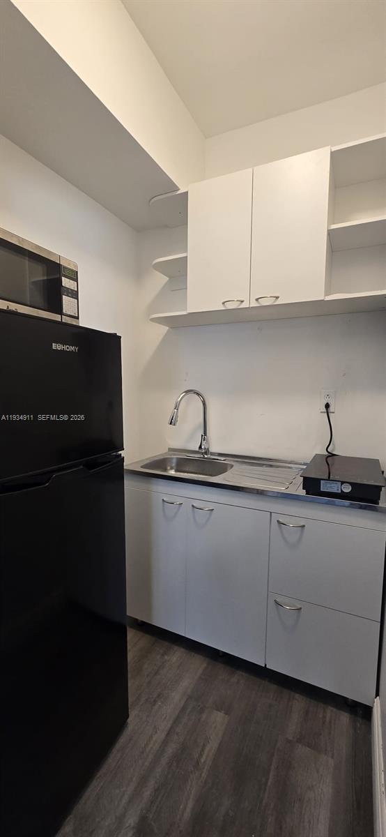 8430 Harding Avenue, Unit 4A Miami Beach, FL 33141 - Photo 8 of 43 a kitchen with granite countertop white cabinets and a sink