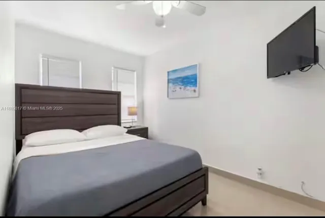 a bedroom with a bed and flat screen tv