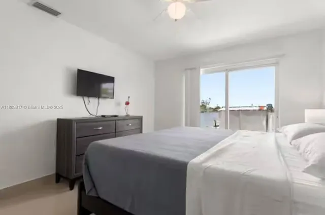 a bedroom with a bed and a flat screen tv