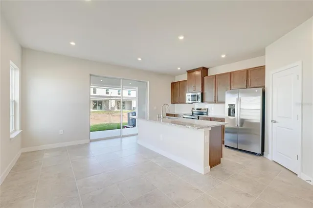 a large kitchen with kitchen island a sink stainless steel appliances and cabinets