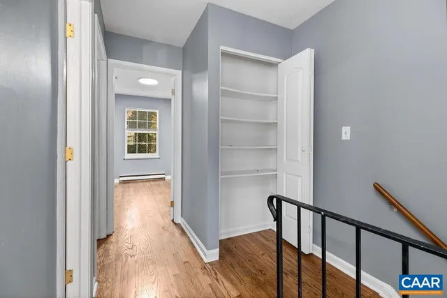 a view of a hallway with wooden floor and staircase