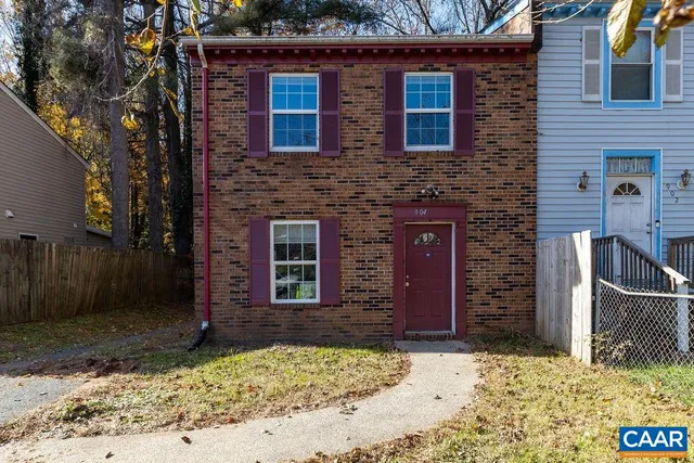 a brick house with a small yard in front of it