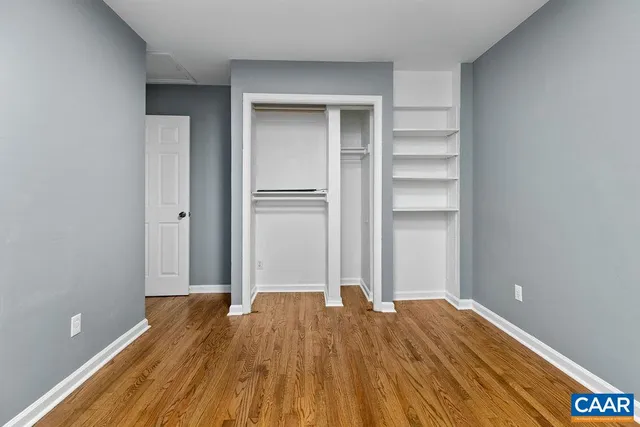 a view of empty room with wooden floor