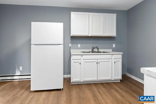 a kitchen with a sink a refrigerator and cabinets
