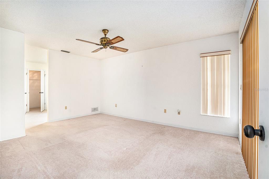 1247 Venetia Drive Spring Hill, FL 34608 - Photo 16 of 27 an empty room with windows and fan