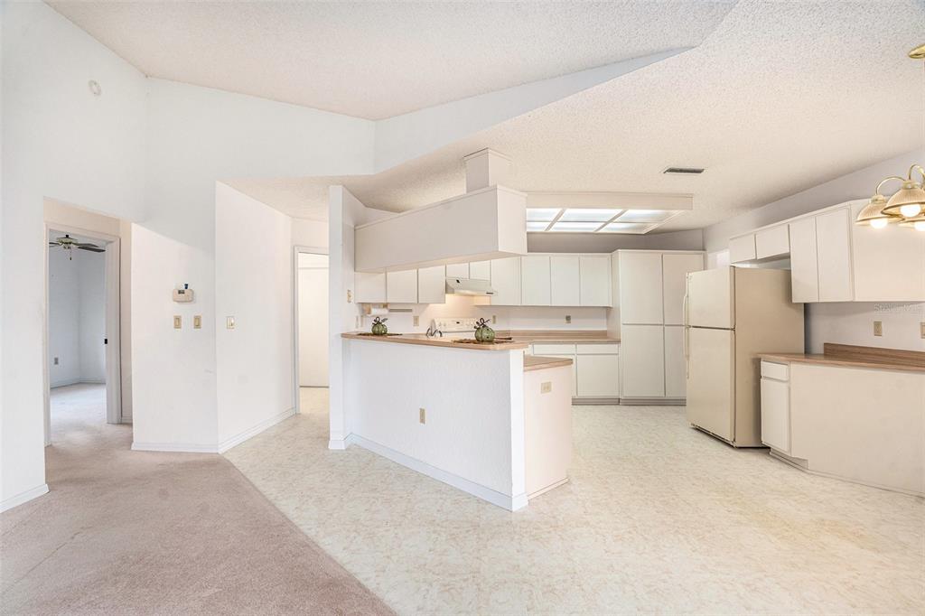 1247 Venetia Drive Spring Hill, FL 34608 - Photo 7 of 27 a kitchen with white cabinets and white appliances