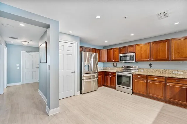 a large kitchen with stainless steel appliances granite countertop a stove and a sink