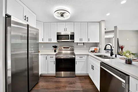 a kitchen with cabinets stainless steel appliances and a sink