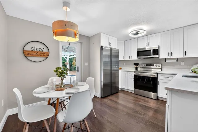 a kitchen with stainless steel appliances a table chairs and a refrigerator