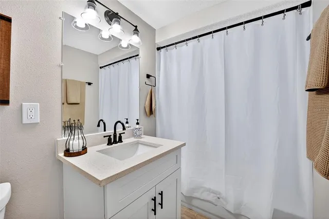 a bathroom with a sink vanity and a mirror