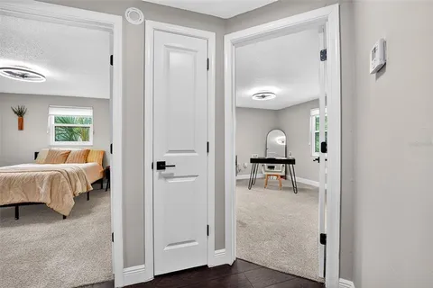a view of a bedroom with a bed and wooden floor